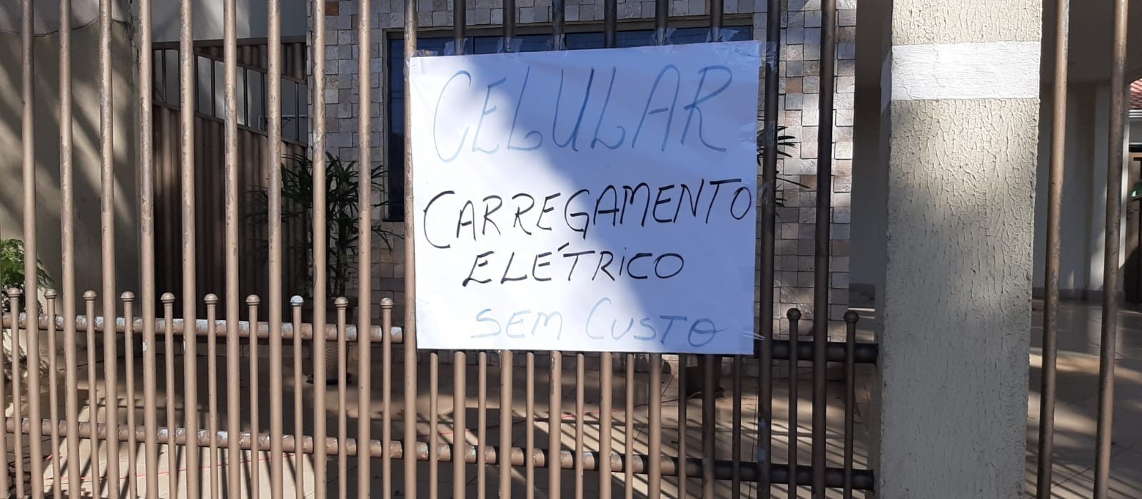 Morador coloca tomada no portão de casa para pessoas sem energia carregarem celular em Maringá